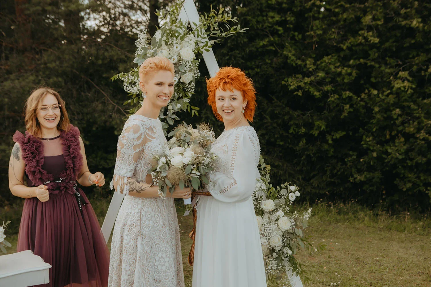 Divas līgavas pie ceremonijas altāra ar ziediem